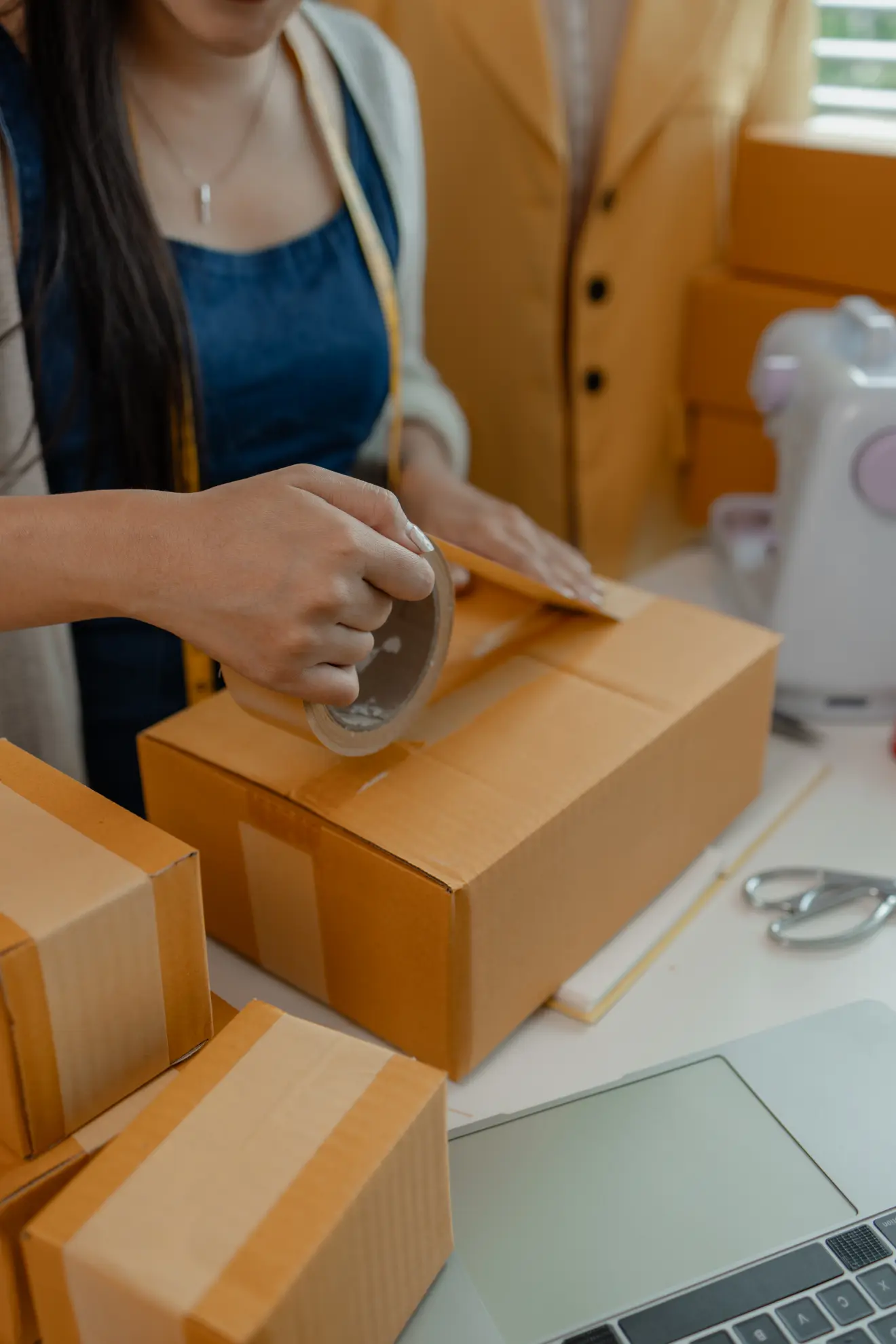 Couple packing moving boxes in a modern living room with open door and stacked cardboard boxes near entryway