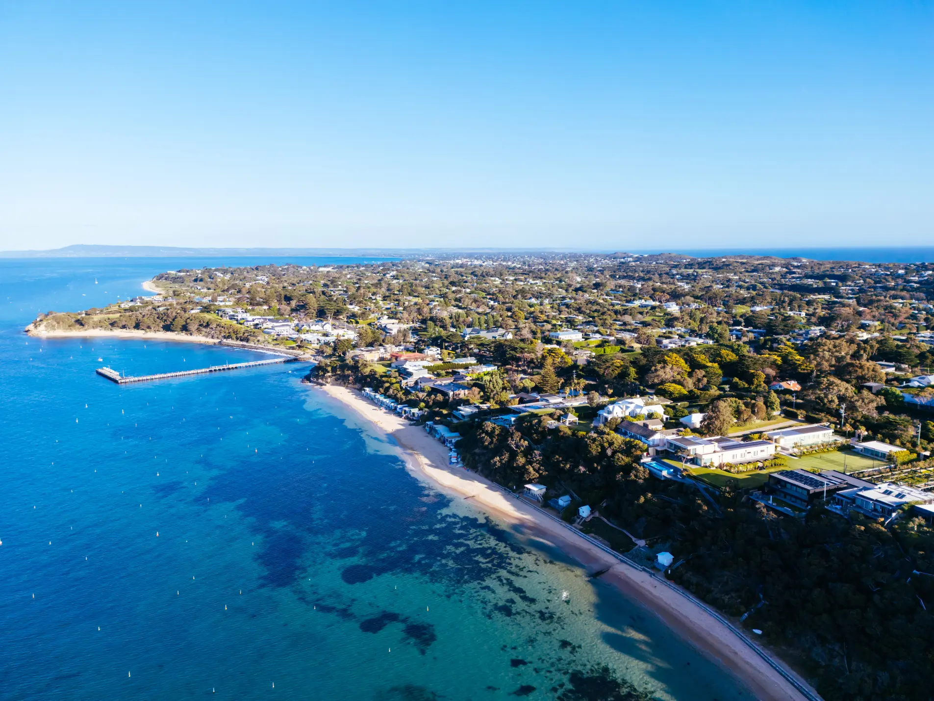 Drone shot of Portsea coastline with beaches, pier, and houses in Australia