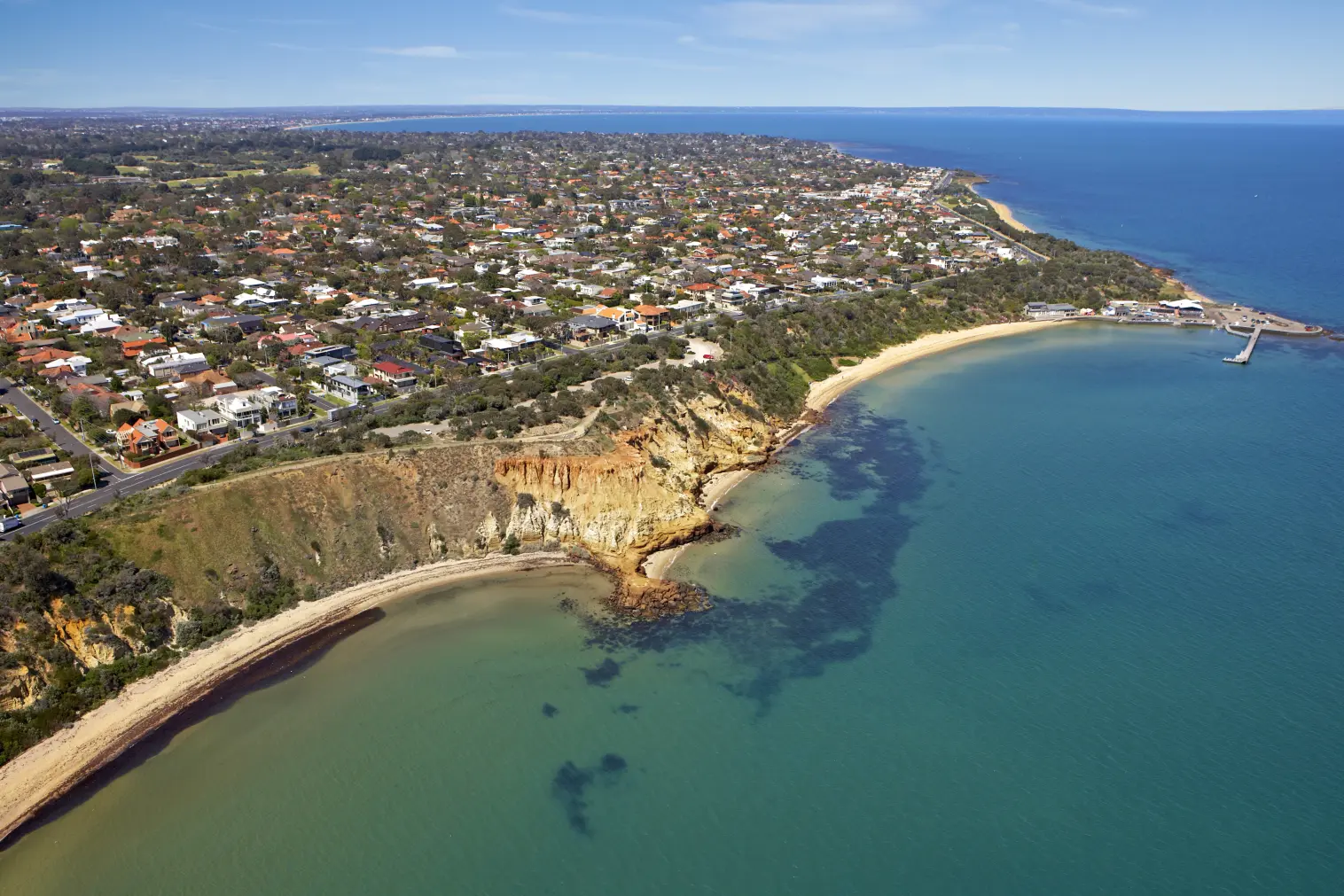 Drone view of Australian coastal town with blue ocean