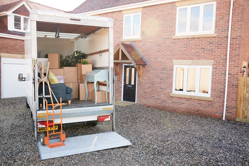 Peninsula Moving truck unloading furniture and boxes outside a modern brick home in Mornington Peninsula