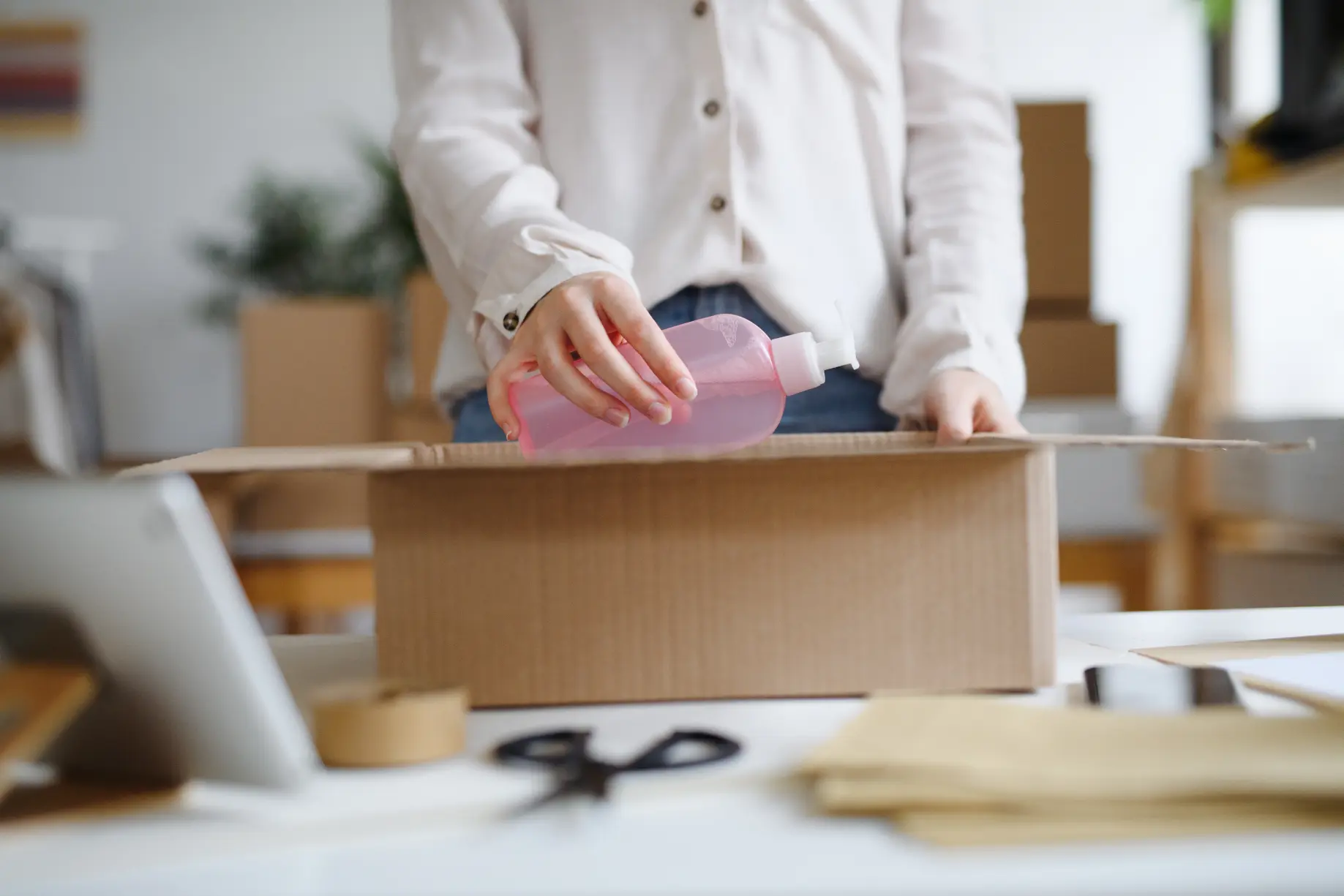 Couple packing moving boxes in a modern living room with open door and stacked cardboard boxes near entryway